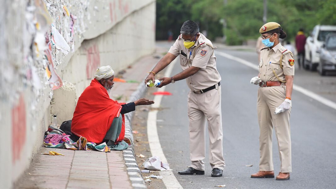 New Delhi police officers provide hand sanitizer to a homeless man on the third day of India’s national lockdown. RAJ K RAJ/HINDUSTAN TIMES/SIPA USA