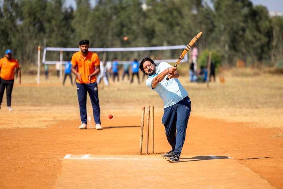 Palwankar Baloo: The Pioneering Cricketer Who Faced Discrimination, His Stories of Resilience A cricket player in mid-swing during an outdoor match on a sunny day.