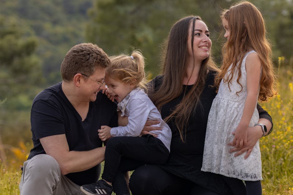 A joyful family enjoying a moment outdoors with their daughters.
