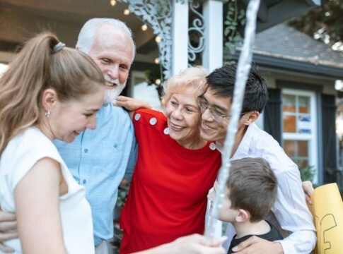 A joyful multigenerational family gathering, embracing each other outdoors with happiness. A joyful multigenerational family gathering, embracing each other outdoors with happiness.