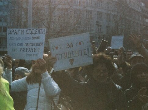 A large group of students holding signs during a peaceful protest outdoors. A large group of students holding signs during a peaceful protest outdoors.