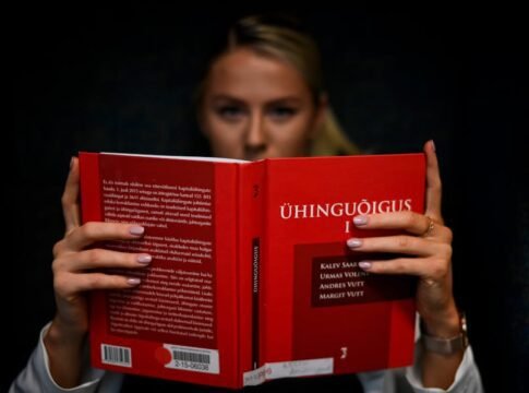 A law student intensely reading a legal textbook indoors in Tallinn, Estonia.