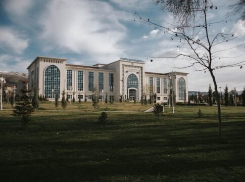 A modern building with arched windows and glass panels under a cloudy sky in Malatya, Türkiye.