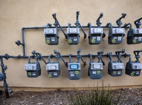 A neat installation of gas meters mounted on an exterior wall in an urban setting.