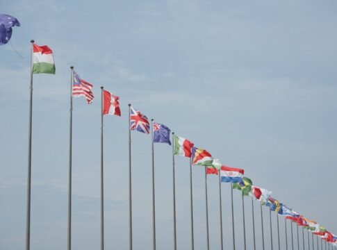A row of international flags on flagpoles symbolizing global unity and diplomacy.