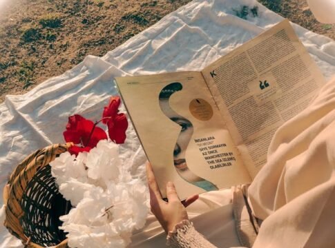 A serene scene of a woman reading a magazine outdoors on a sunny day.