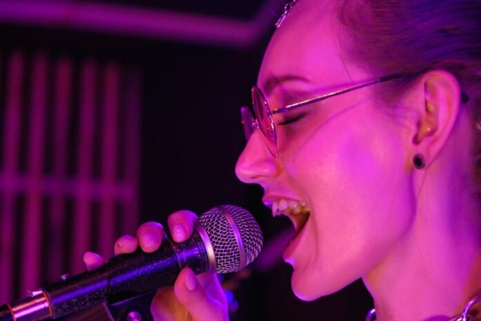 A vibrant close-up of a female singer performing with passion under purple stage lights. A vibrant close-up of a female singer performing with passion under purple stage lights.