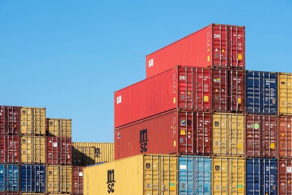 India Weighs Further Support for Exporters Amidst West Asia Crisis A vibrant collection of stacked shipping containers under a clear, blue sky. Ideal for logistic themes.
