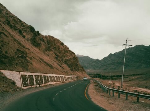 A winding road leads through the rugged and scenic Ladakh mountains, capturing the essence of adventure travel.