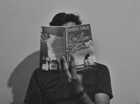 A young man reads 'Can Love Happen Twice?' in a black and white portrait. A young man reads 'Can Love Happen Twice?' in a black and white portrait.