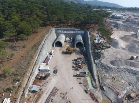 Aerial shot of Yeniçam tunnel construction site in Çanakkale, Turkey, showcasing heavy machinery and forest surroundings. Aerial shot of Yeniçam tunnel construction site in Çanakkale, Turkey, showcasing heavy machinery and forest surroundings.