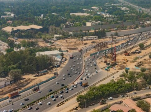 Aerial shot of busy expressway in New Delhi, showcasing traffic and city development. Aerial shot of busy expressway in New Delhi, showcasing traffic and city development.