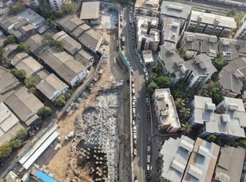 Aerial view of construction site amidst dense urban architecture in Mumbai, India.