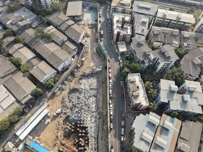 Aerial view of construction site amidst dense urban architecture in Mumbai, India. Aerial view of construction site amidst dense urban architecture in Mumbai, India.
