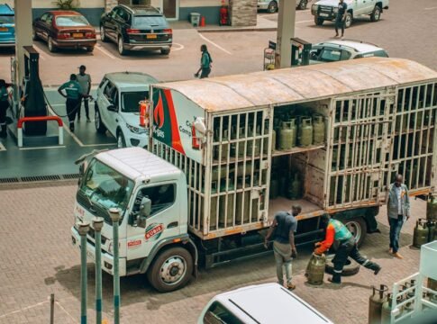 An LPG gas truck making a delivery at a busy urban station.