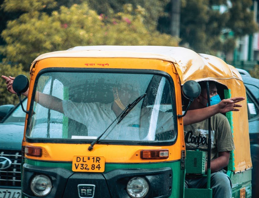 Auto rickshaw navigating the rainy streets of Delhi with passengers gesturing directions.
