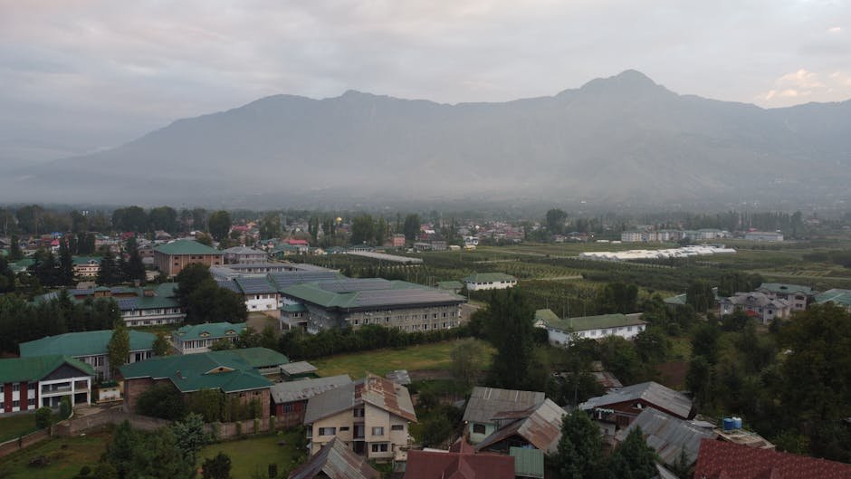 Kashmir Braces for Continued Rain and Snow as Western Disturbance Intensifies Beautiful aerial view of Srinagar cityscape with lush greenery and distant mountains.