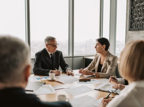 Business professionals engaged in a strategic meeting in a modern office setting with natural light.