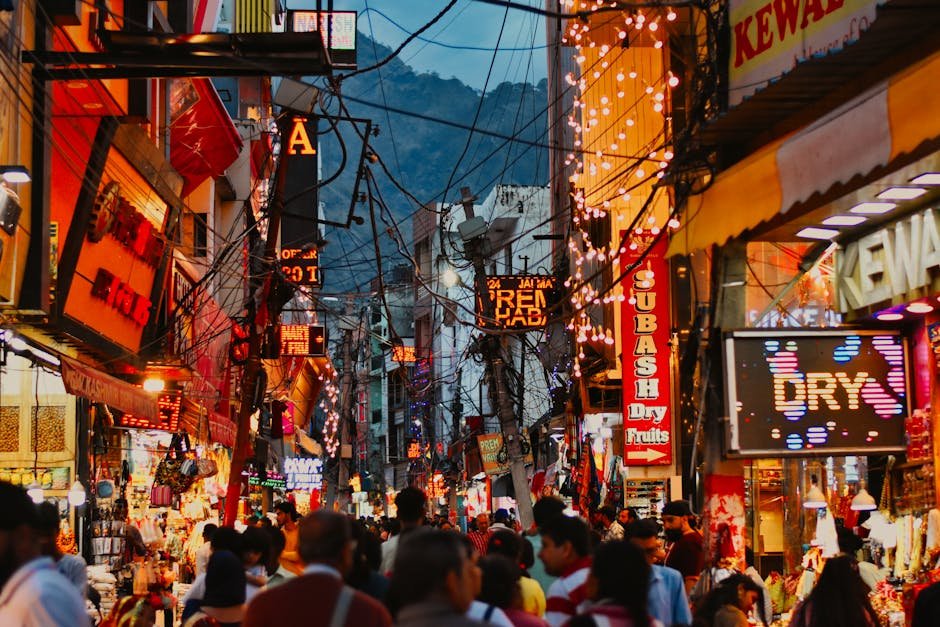 Bustling evening street market in Katra, India with colorful lights and crowds.
