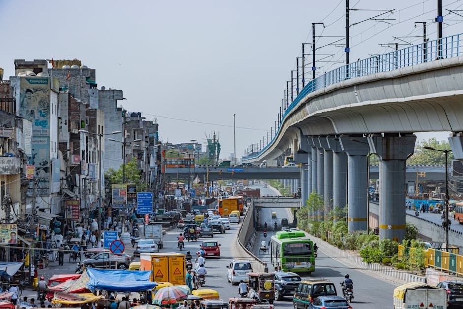 Busy street scene in Delhi with elevated metro and urban traffic capturing vibrant city life.