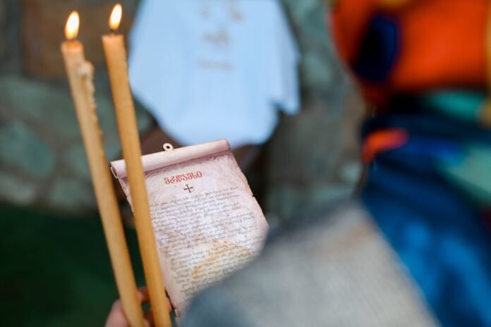 Close-up of a religious ceremony with lit candles and an Orthodox prayer scroll. Close-up of a religious ceremony with lit candles and an Orthodox prayer scroll.