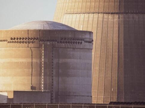 Close-up view of nuclear reactor buildings bathed in golden light, showcasing industrial architecture.