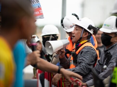 Construction workers in a heated protest with security present. Safety and communication emphasized.
