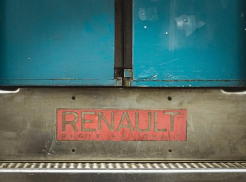 Detail of a Renault vehicle with the brand badge prominently displayed on metal background.