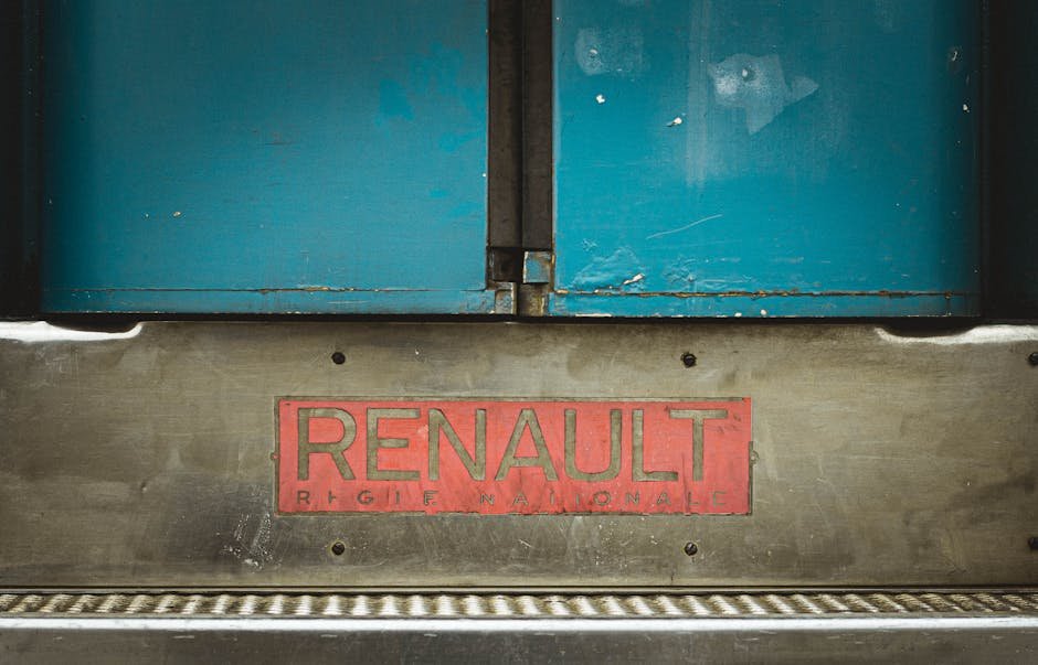 Detail of a Renault vehicle with the brand badge prominently displayed on metal background.