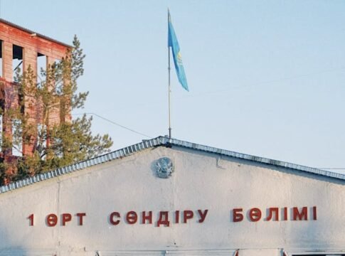 Fire station building in Konaev, featuring Kazakh flag and signage, captured in daylight.