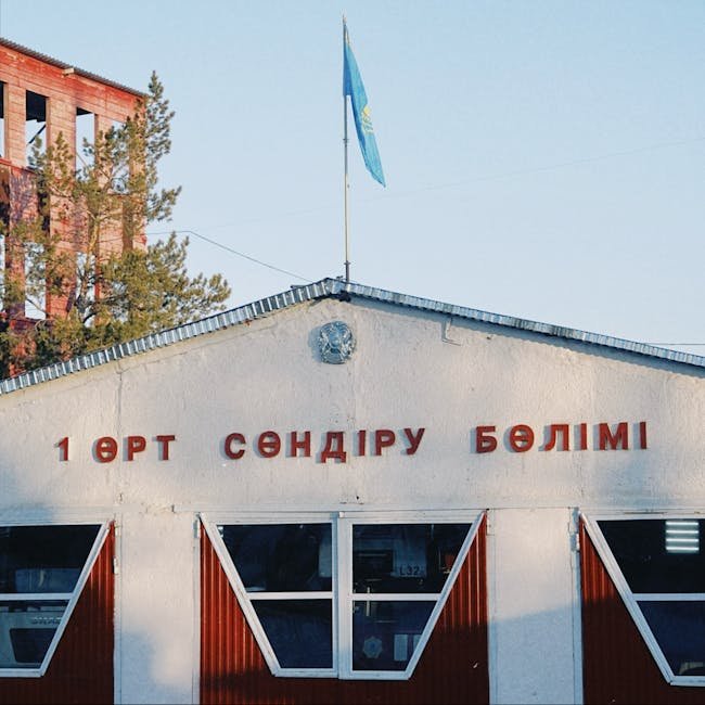 Fire station building in Konaev, featuring Kazakh flag and signage, captured in daylight. Fire station building in Konaev, featuring Kazakh flag and signage, captured in daylight.