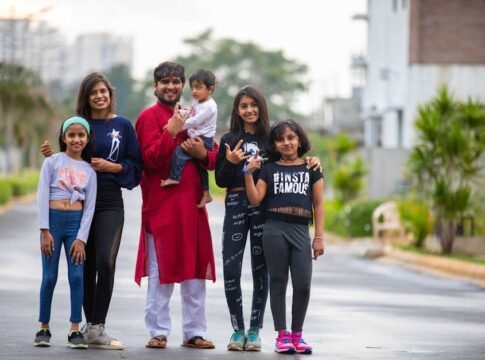 Group of people posing outdoors with trendy outfits showcasing lively family spirit.