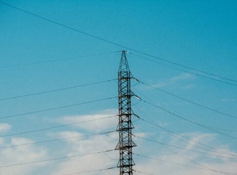 High voltage power lines stretching into blue sky with scattered clouds. High voltage power lines stretching into blue sky with scattered clouds.