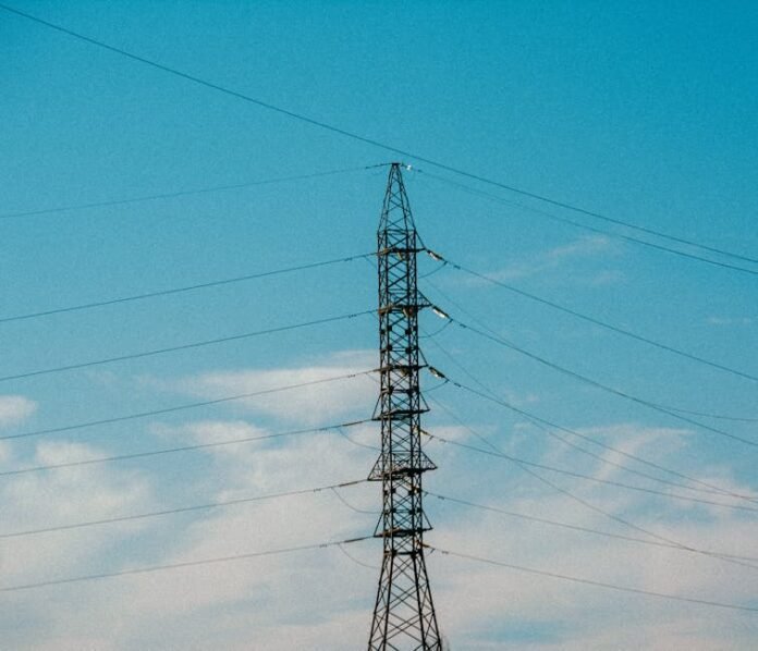 High voltage power lines stretching into blue sky with scattered clouds. High voltage power lines stretching into blue sky with scattered clouds.
