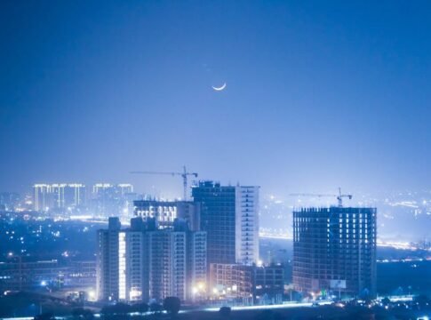 Illuminated cityscape of Greater Noida at night with a crescent moon enhancing the urban skyline. Illuminated cityscape of Greater Noida at night with a crescent moon enhancing the urban skyline.