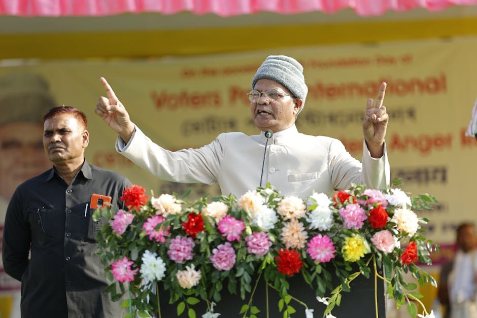 Man delivering a powerful public speech outdoors with a floral adorned podium.
