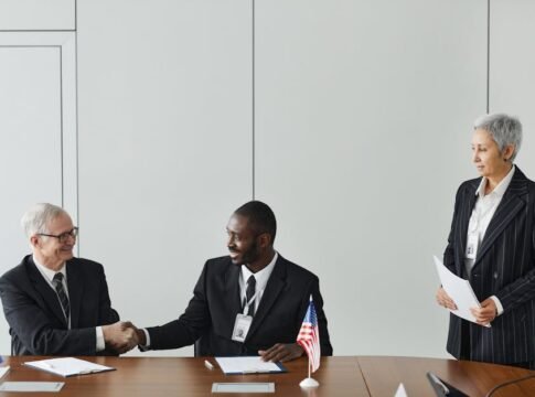 Multinational business meeting with agreement signing, featuring diverse professionals and flags. Multinational business meeting with agreement signing, featuring diverse professionals and flags.