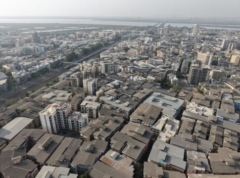 Panoramic aerial view of Mumbai's sprawling urban landscape showcasing dense buildings and roads. Panoramic aerial view of Mumbai's sprawling urban landscape showcasing dense buildings and roads.