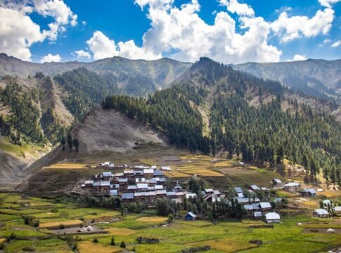 Panoramic view of Gurez village in Kashmir, surrounded by lush mountains and fields.