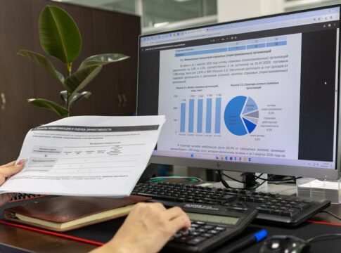Person analyzing financial data on a computer screen in an office setting.