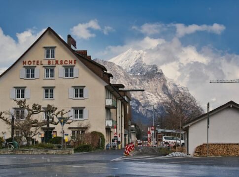 Picturesque hotel in Swiss village with majestic mountain in winter scenery.