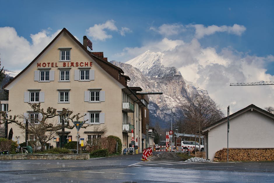 Picturesque hotel in Swiss village with majestic mountain in winter scenery.
