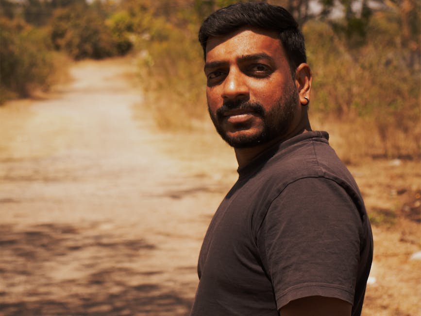 Uttar Pradesh Man Dies by Suicide Over Sister’s Wedding Expenses Portrait of a man with short hair on a rural dirt road in Bangalore, India.