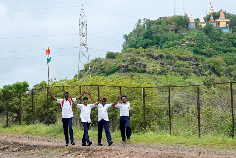 Pune School Honors Late Football Star Aariz Shaikh with Memorial Tournament and Jersey Retirement School boys in uniform walking joyfully outdoors with an Indian flag, near a lush hill in Pune, India.