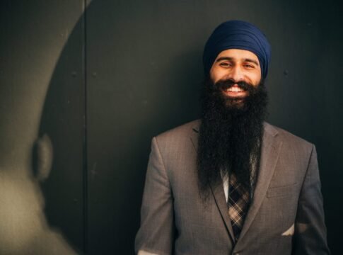 Smiling man in corporate attire with a long beard, exuding confidence. Smiling man in corporate attire with a long beard, exuding confidence.