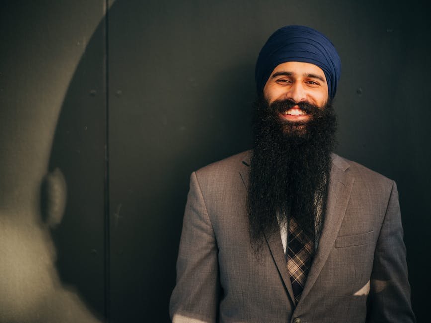 Kapurthala Student Excels in CBSE Class 10, Secures 99.4% Amidst International Olympiad Success Smiling man in corporate attire with a long beard, exuding confidence.