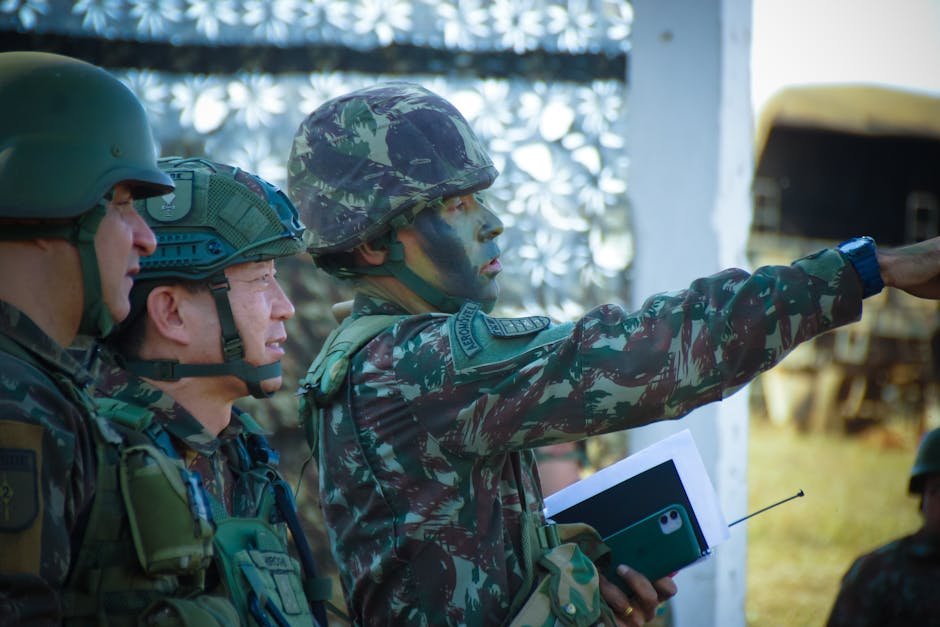 Soldiers in camouflage and helmets strategizing outdoors, focusing on a mission directive.