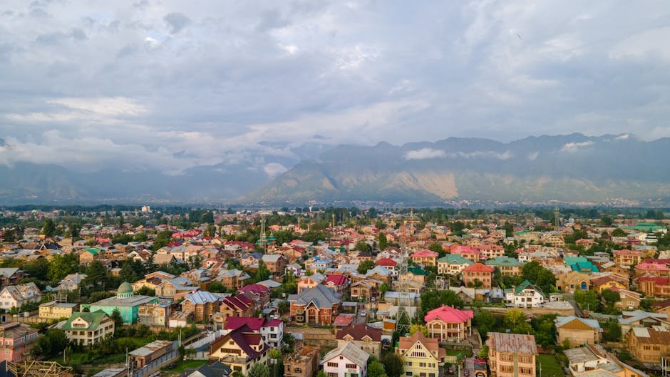 Jammu and Kashmir Industrial Revival Hinges on Special Debt Settlement Stunning aerial view of colorful Srinagar city with Himalayan backdrop under cloudy skies.