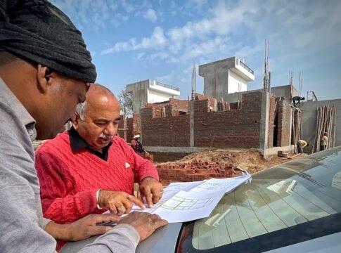 Team of architects examining building plans outdoors at a construction site.