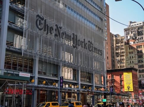 The iconic New York Times building with yellow taxis in bustling Manhattan.